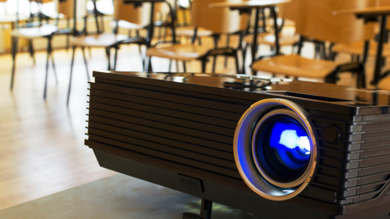 Projector in a classroom full of desks