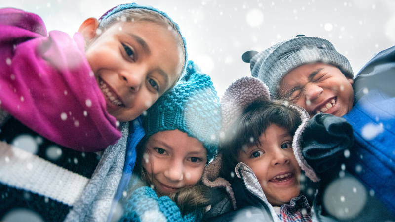 Kids in winter hats huddling together